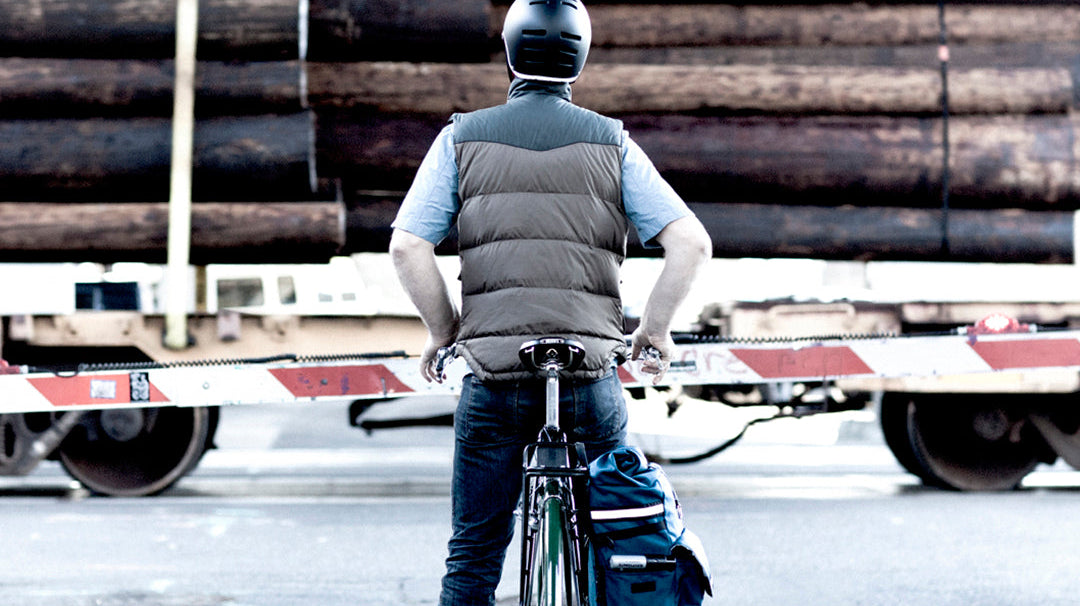 man waiting for a train on his bike in fall layers with a woodward bag