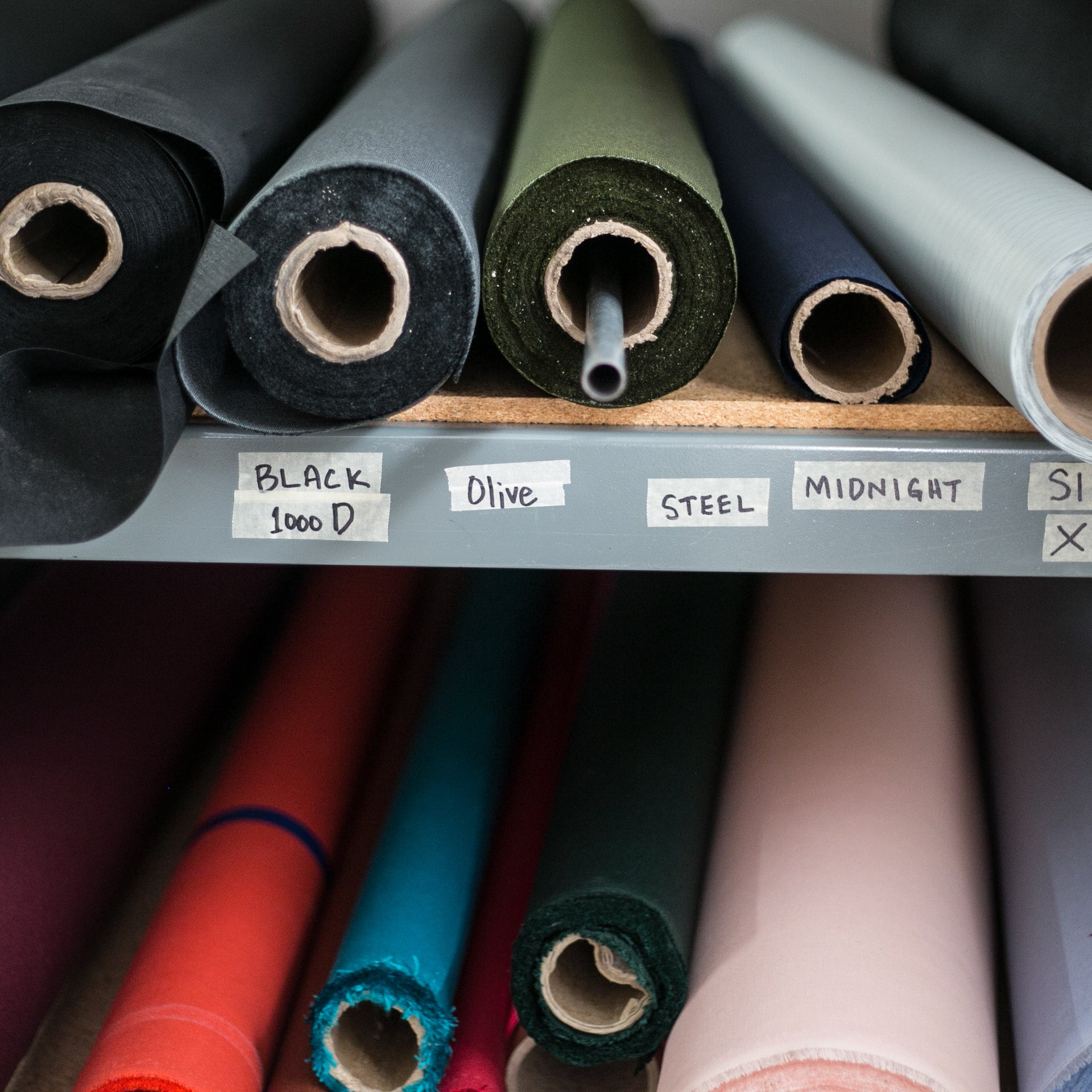 rolls of fabric on a warehouse shelf