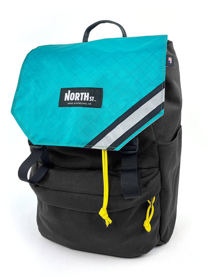 Black backpack with teal top section and yellow drawstring on a white background