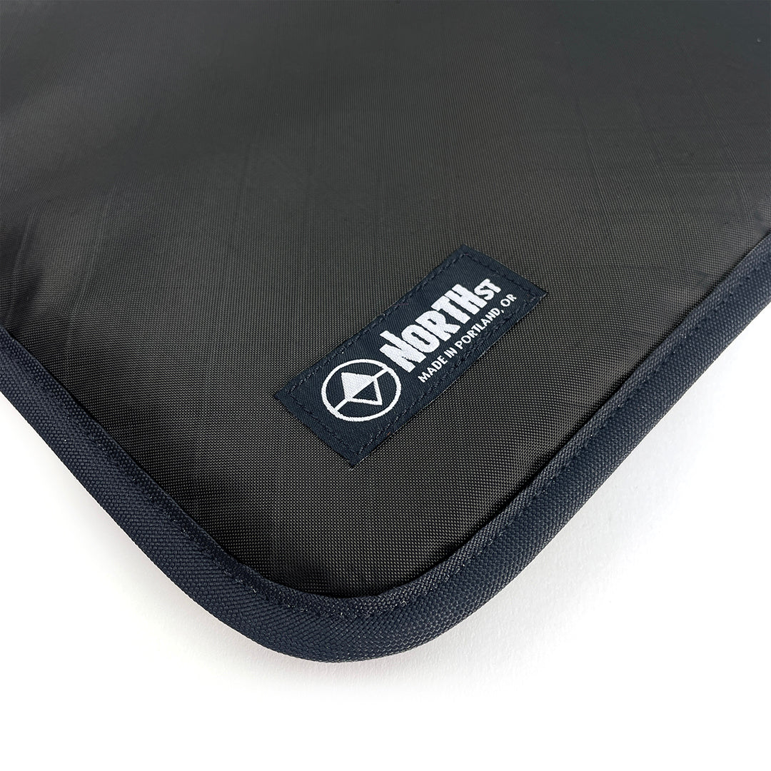 Black laptop sleeve with North St Label visible