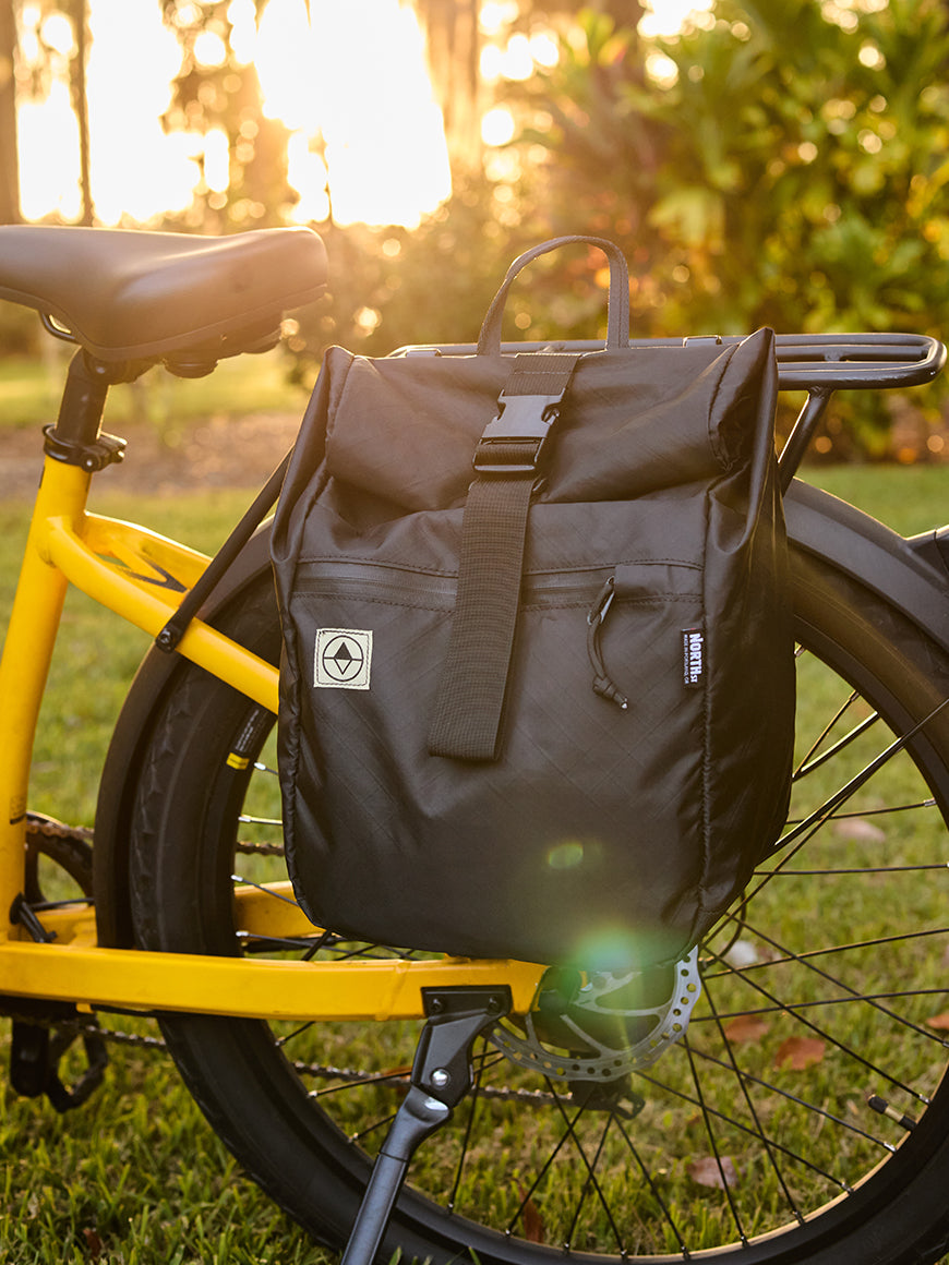 black pannier mounted to a yellow ebike all-groups