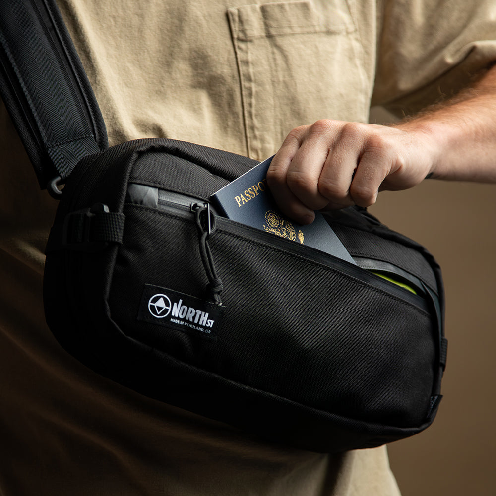 Close up view of man putting passport into a sling strap. all-groups