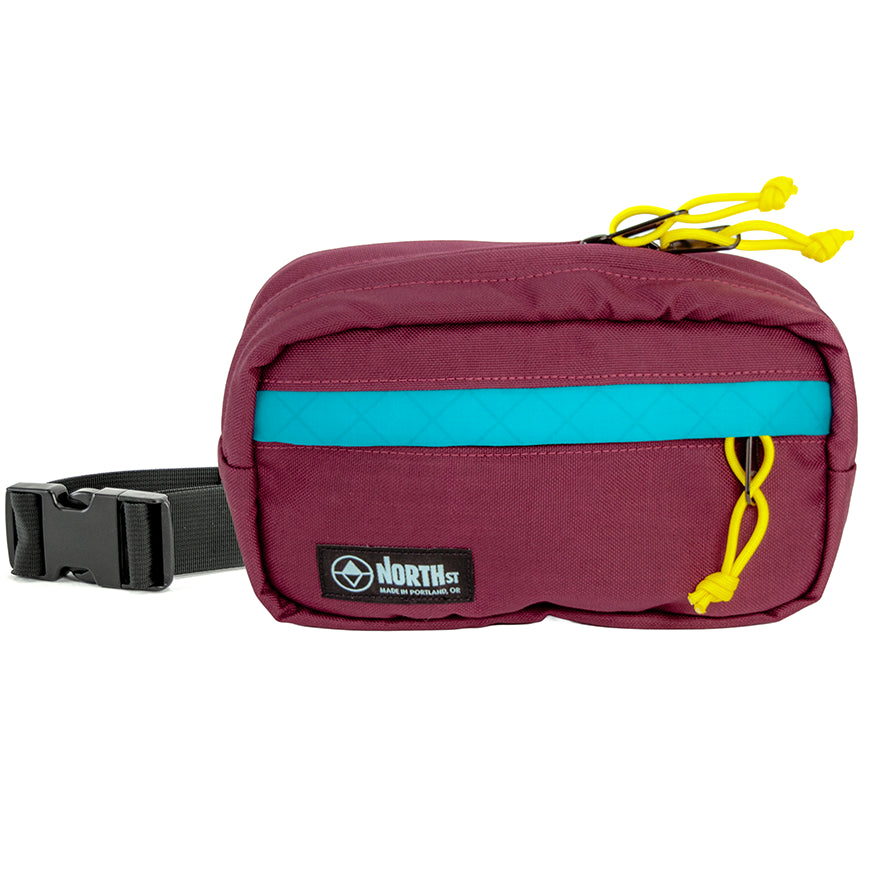 Burgundy waist bag with a visible brand logo on a white background. Pioneer 9 by North St Bags