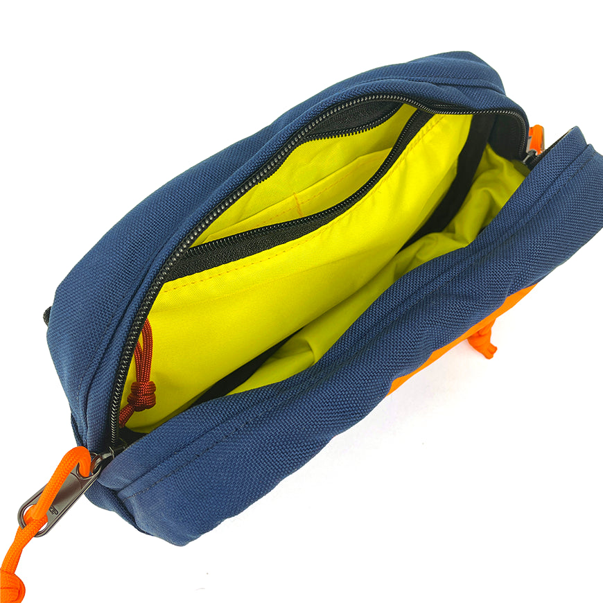 Blue pouch with orange zipper and interior lining on a white background
