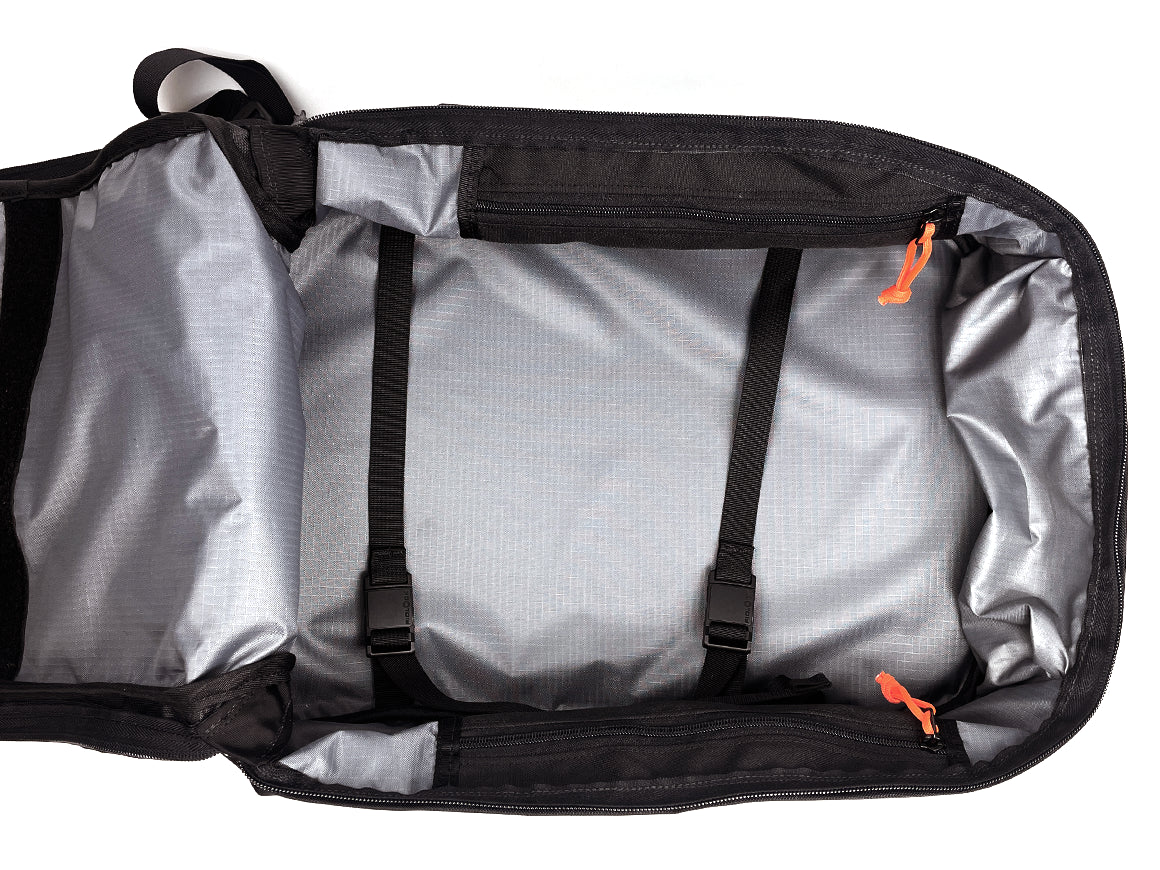 Open dark gray and silver backpack showing the interior with two black compression straps and bright orange zipper pulls on a white background.