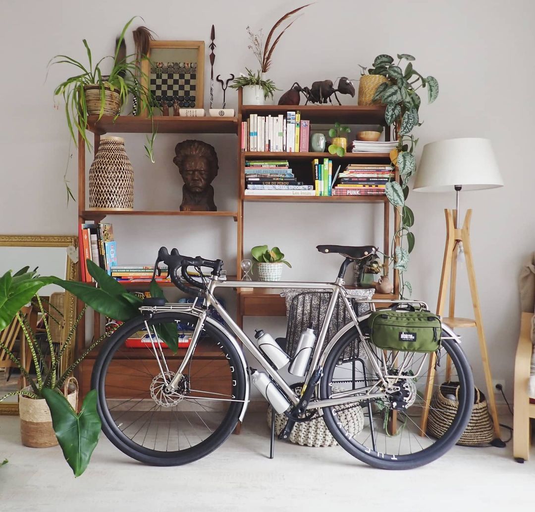 Bike leaning up against shelves in a stylish apartment.