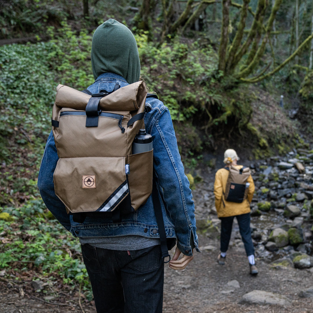 hikers on a forest path wearing backpacks