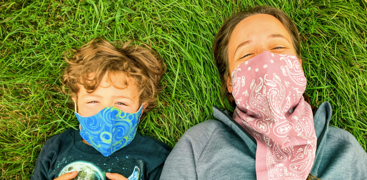mother and son wearing masks in the grass