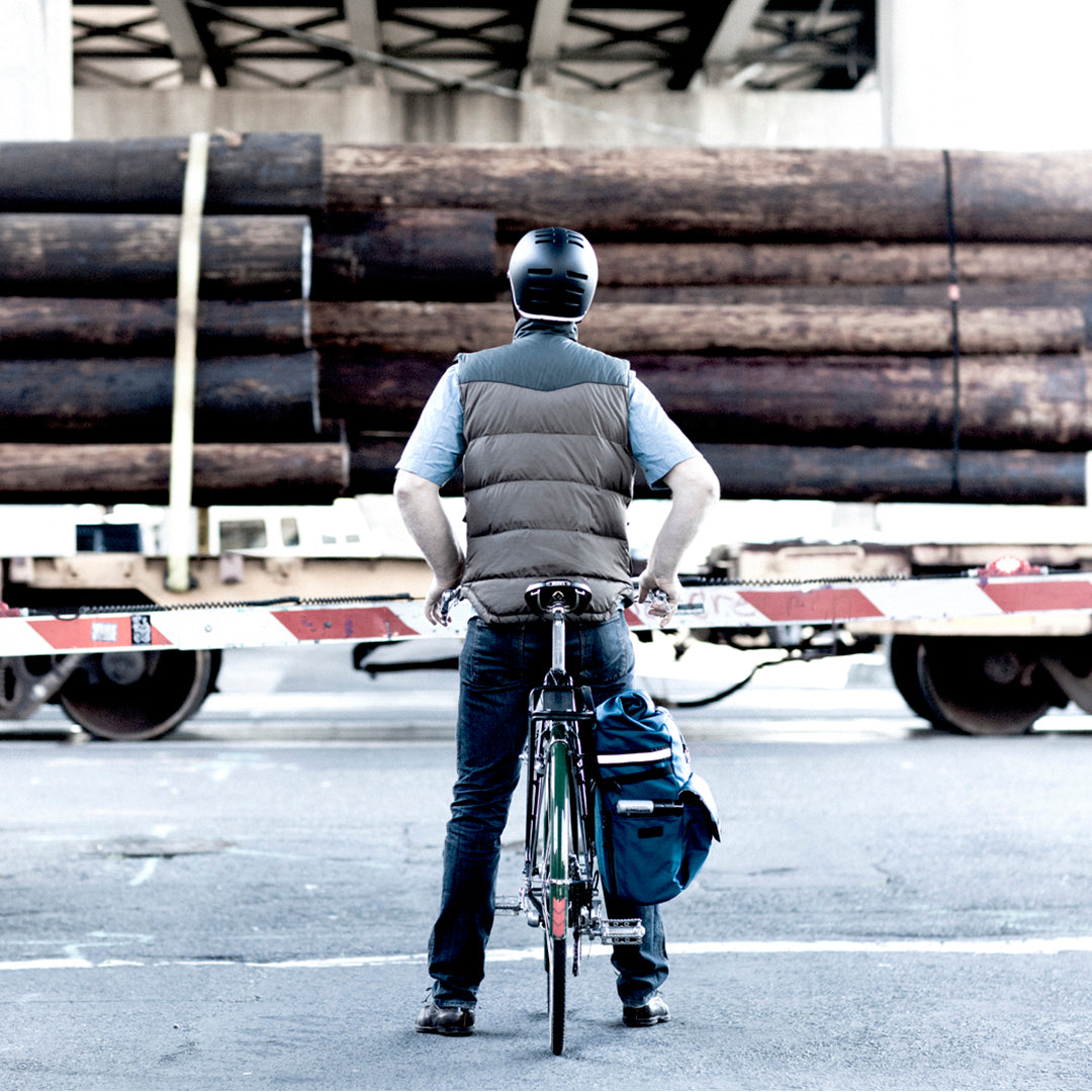 man waiting for a train on his bike in fall layers with a woodward bag