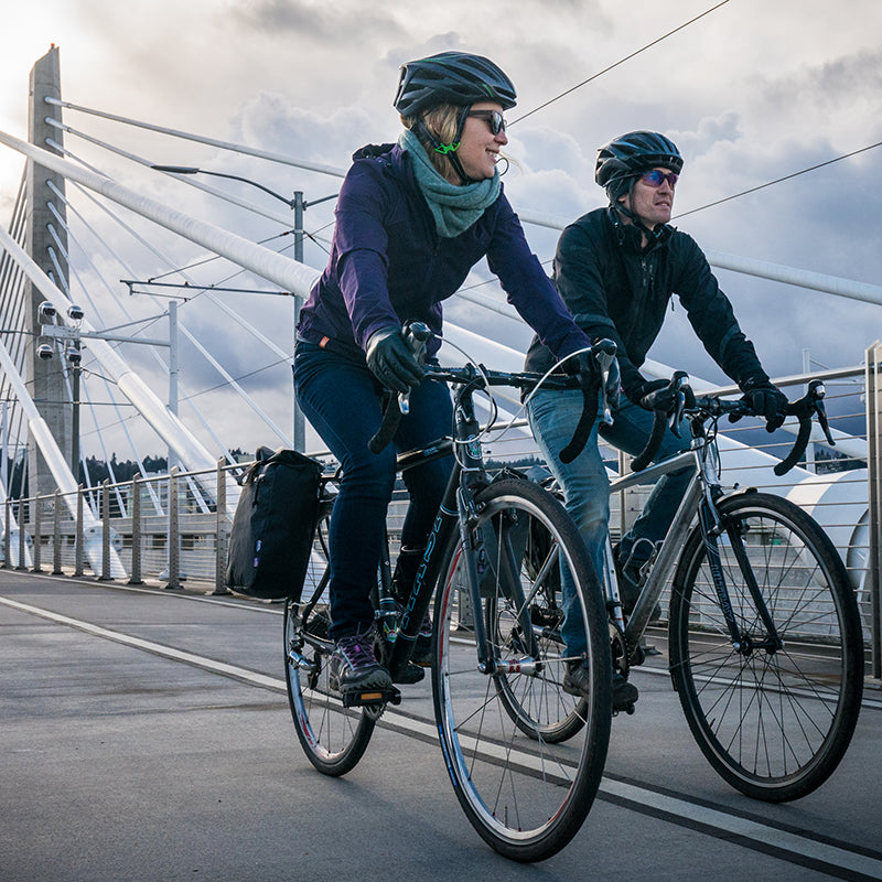 couple biking on a commuter bridge with North St Bags