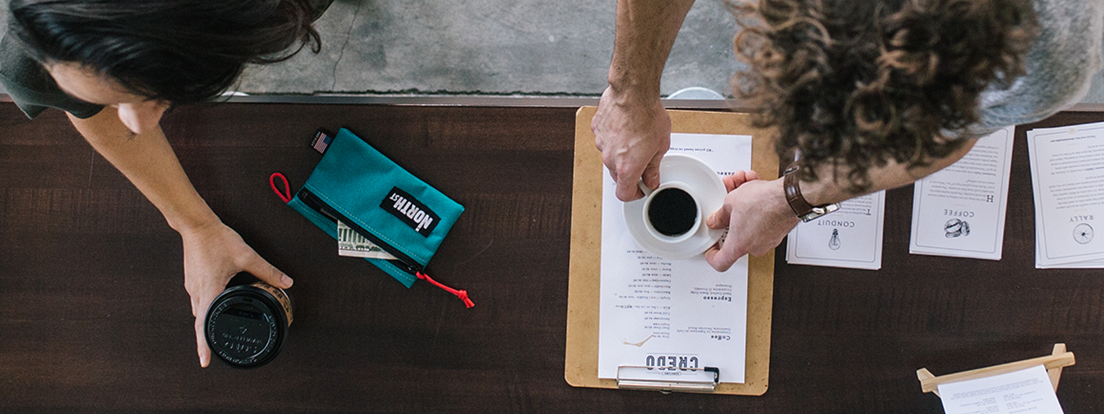 a man and woman order at a hip coffee shop with a North St pouch