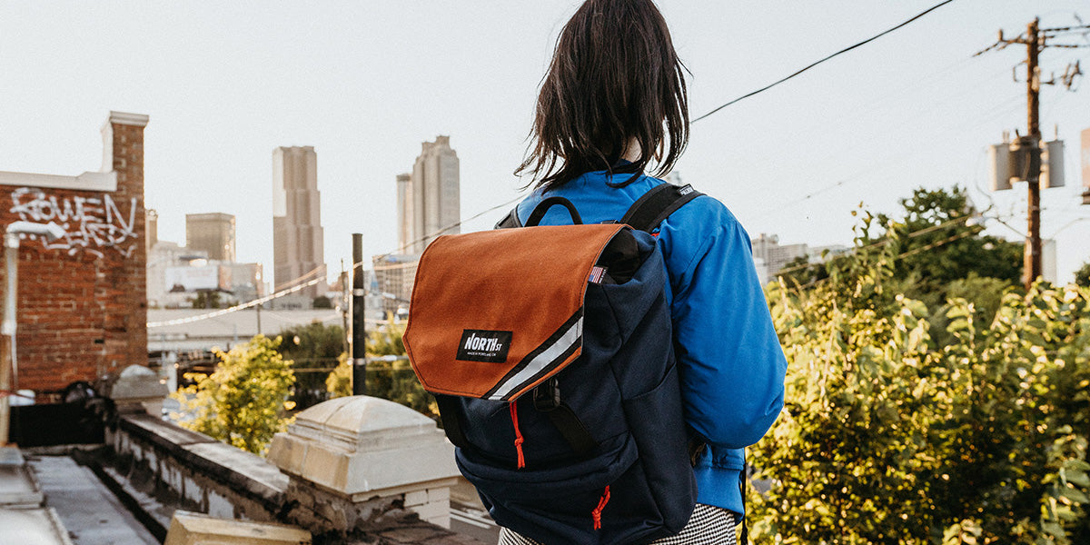 Woman with backpack looking out at San Francisco skyline.