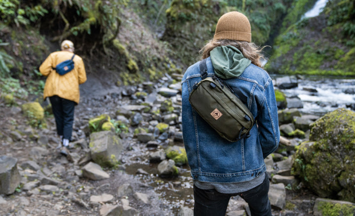 Two hikers on a waterfall trail wearing packs. | North St Bags