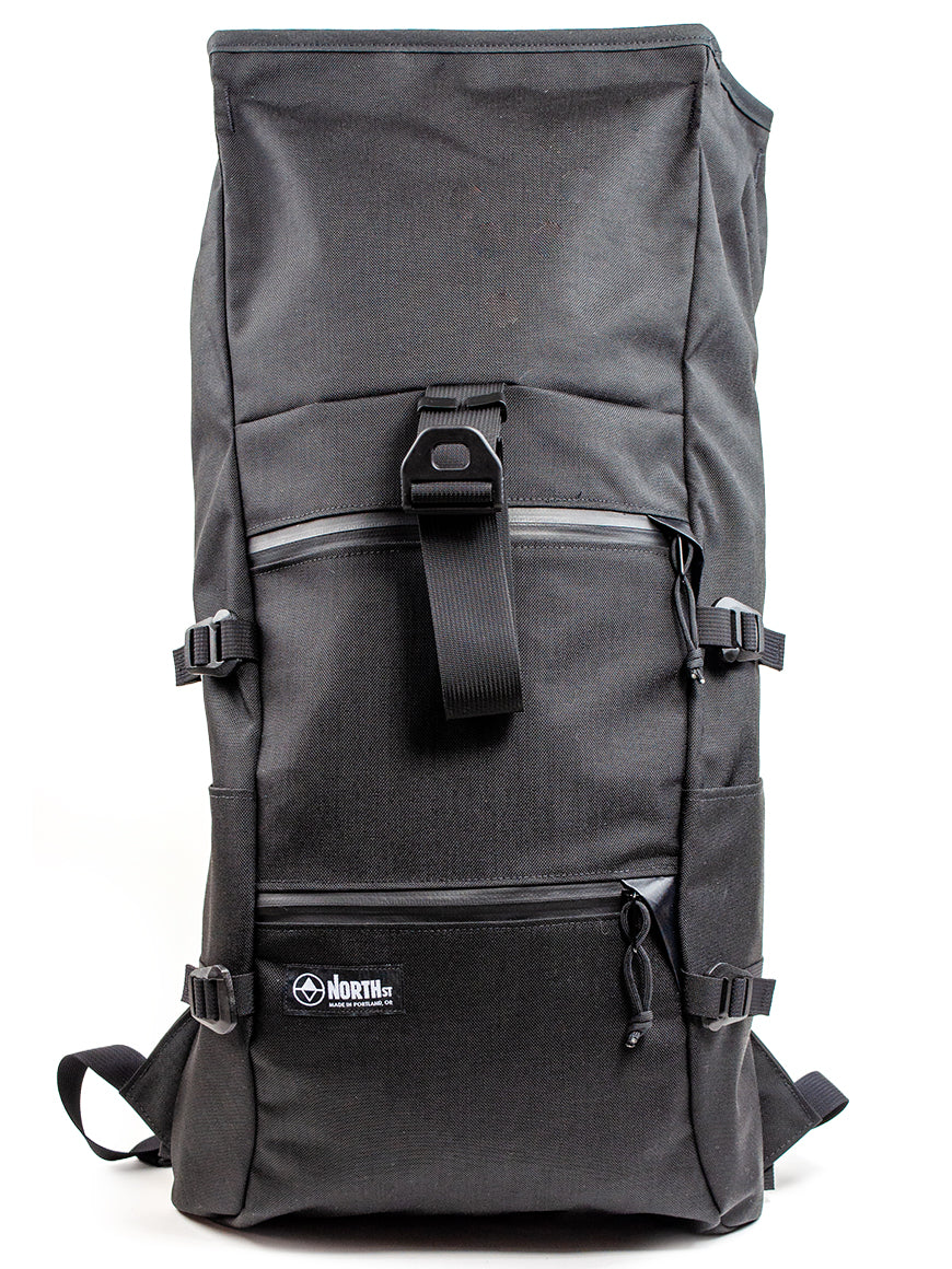 Black roll-top backpack with multiple straps on a white background all-groups
