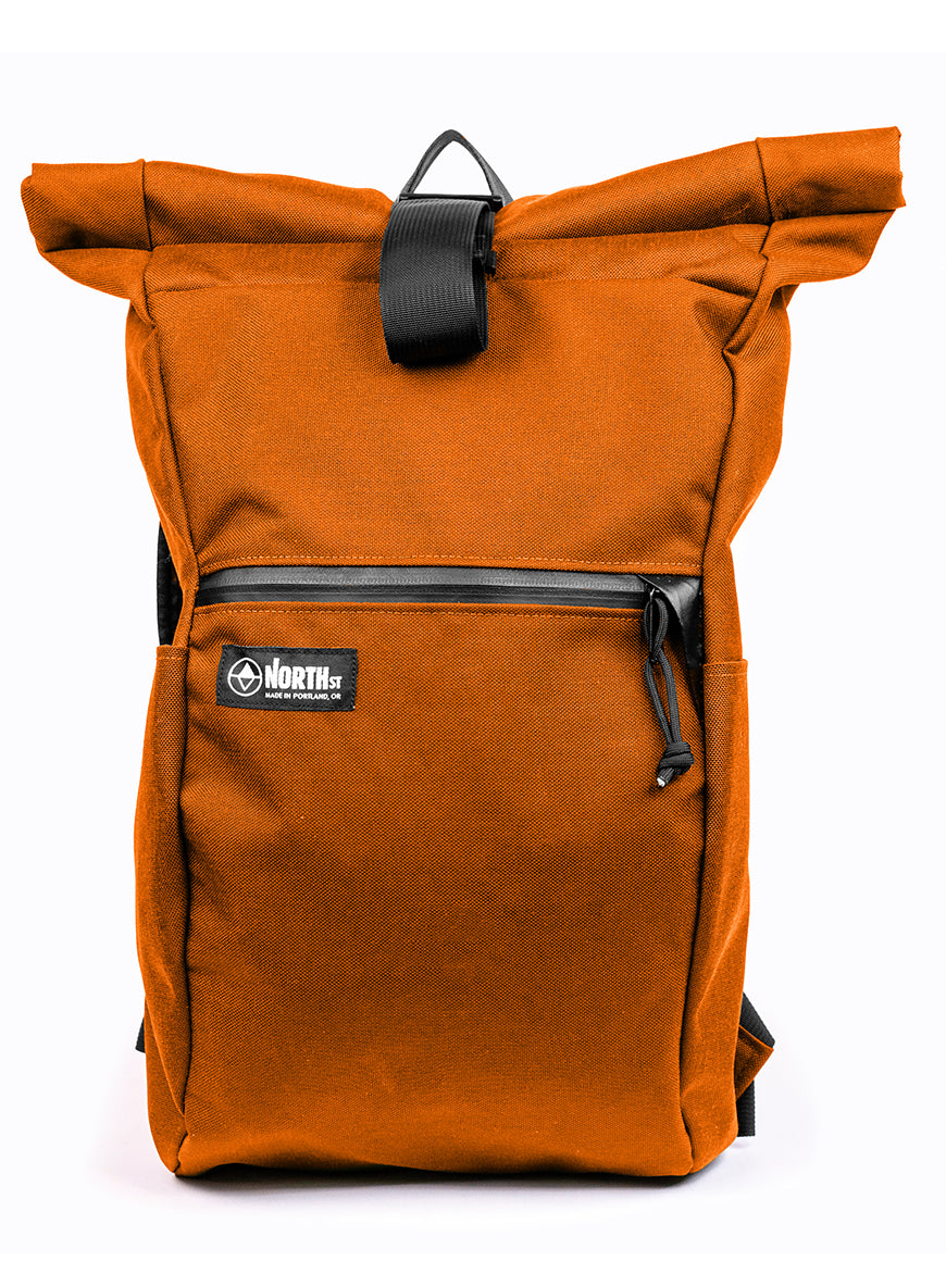 Orange roll-top backpack with a visible brand logo on a white background