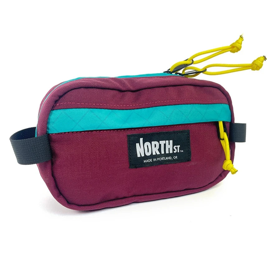 Front view of Pioneer 9 Handlebar Pack in burgundy and teal - North St. Bags