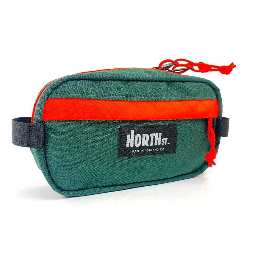 Front view of Pioneer 9 Hip Pack in green and orange. - North St. Bags