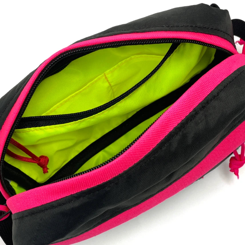 Interior view of Pioneer 9 Hip Pack in black and hot pink with yellow liner. - North St. Bags