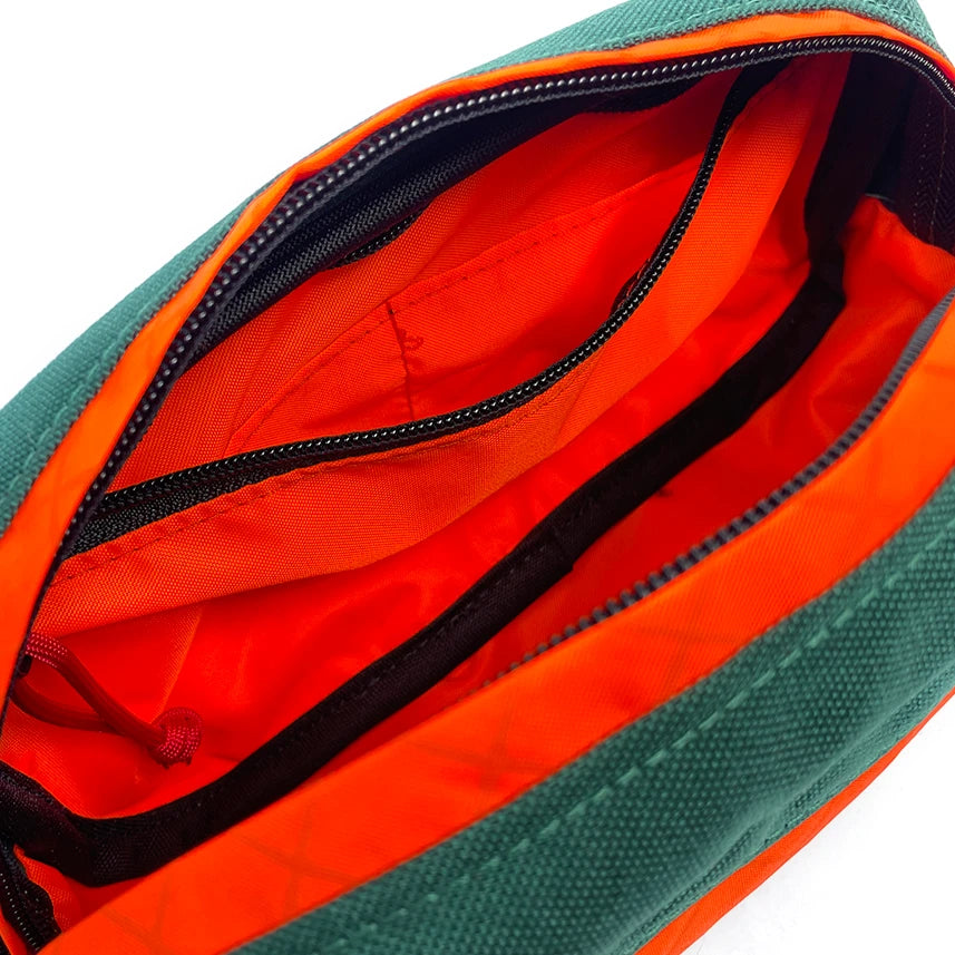 Interior view of Pioneer 9 Hip Pack in green and orange with orange liner. - North St. Bags
