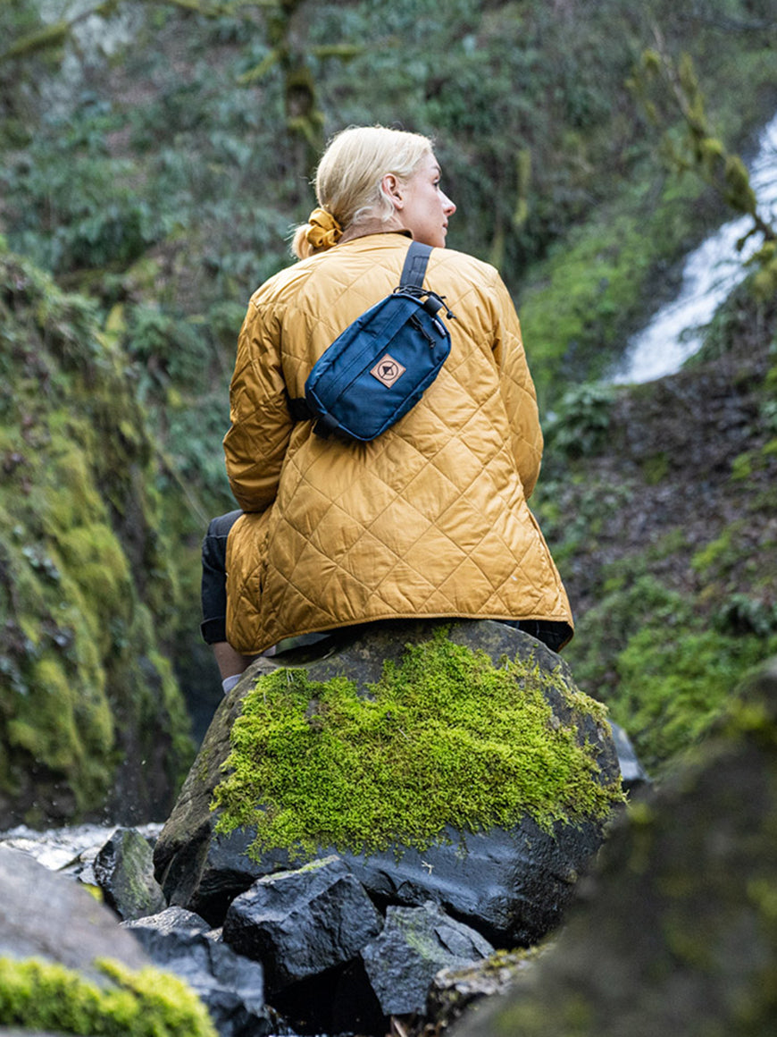 Woman wearing a coat and Pioneer 9 Hip Pack on a waterfall hike - North St. Bags all-groups