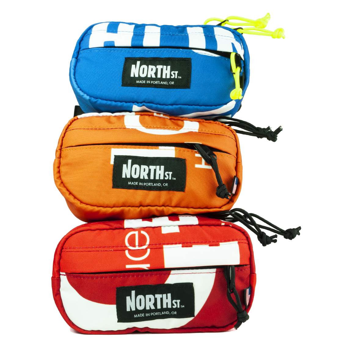 Stack of bright blue, orange, and red fanny packs, hip packs by North Street Bags