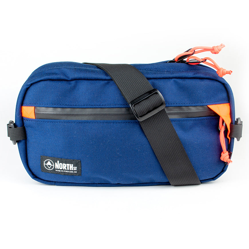 front view of sling pack by North St in midnight and orange