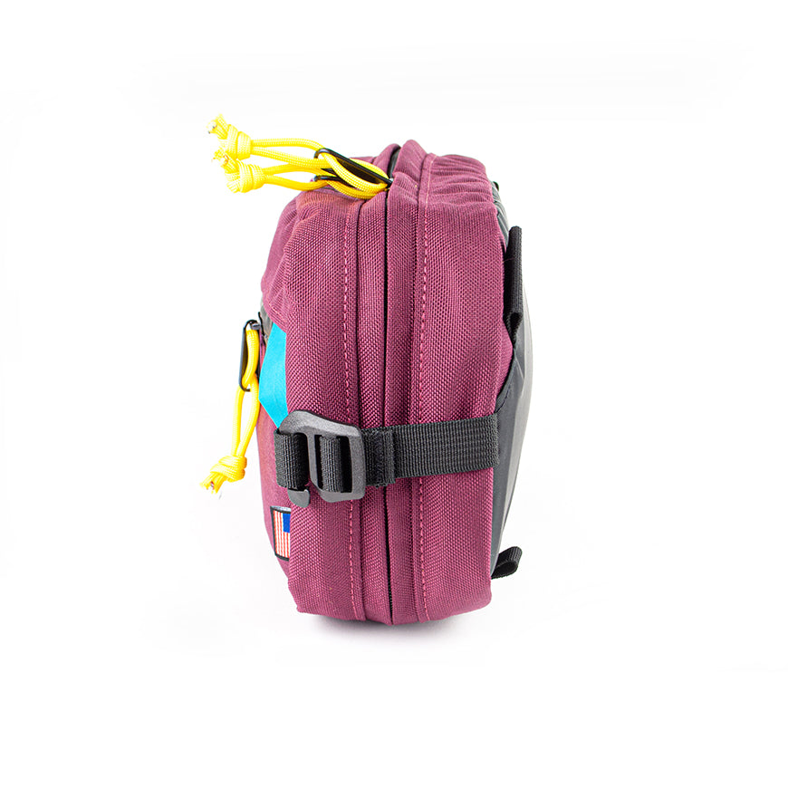 side view of sling pack by North St in burgundy and teal