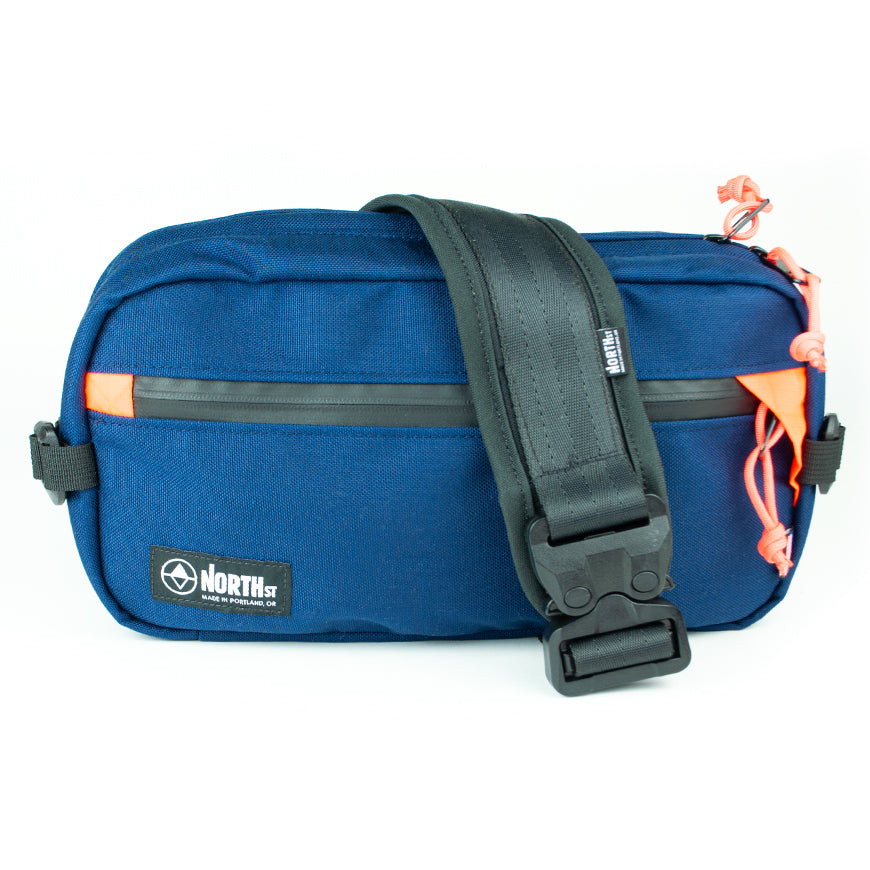 front view of Eliot Sling Pack by North St Bags in Midnight & Orange