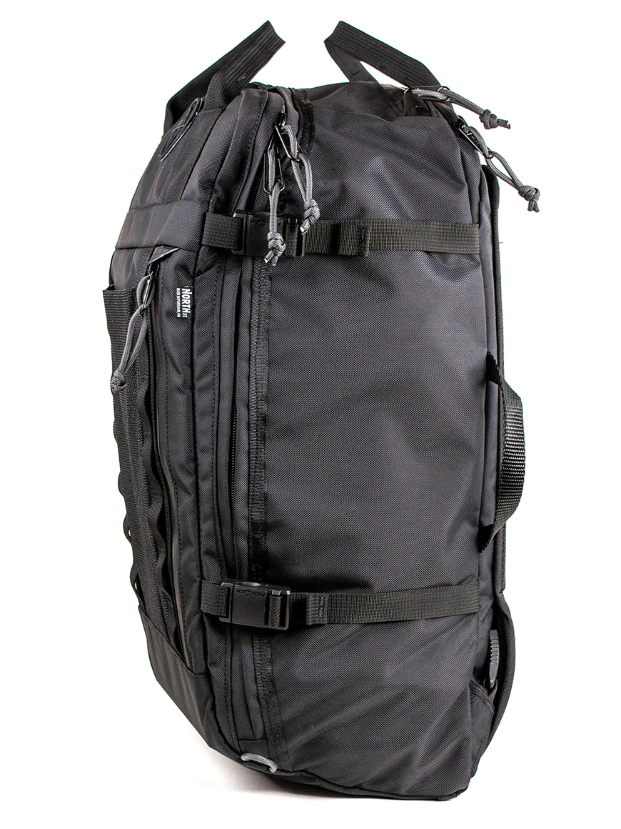 A black travel backpack with multiple compression straps, zipper compartments, and pockets, shown against a plain white background.