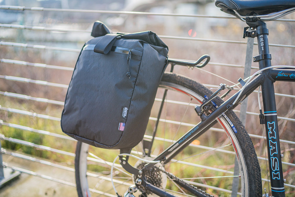 Bicycle pannier in black mounted to a bike. | North St. Bags all-groups