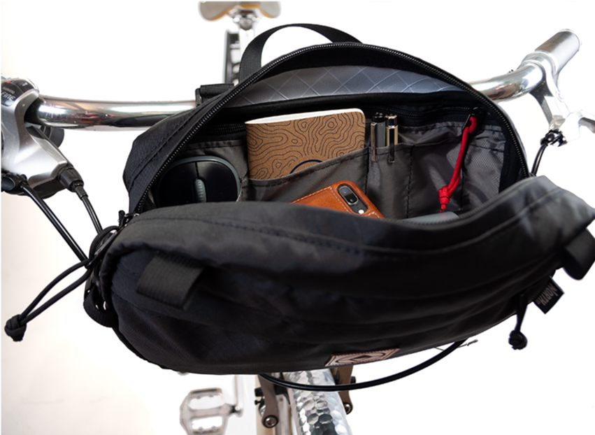 Detail shot of Pioneer 12 Handlebar Pack. Shown opened up with items stored inside. - North St. Bags all-groups